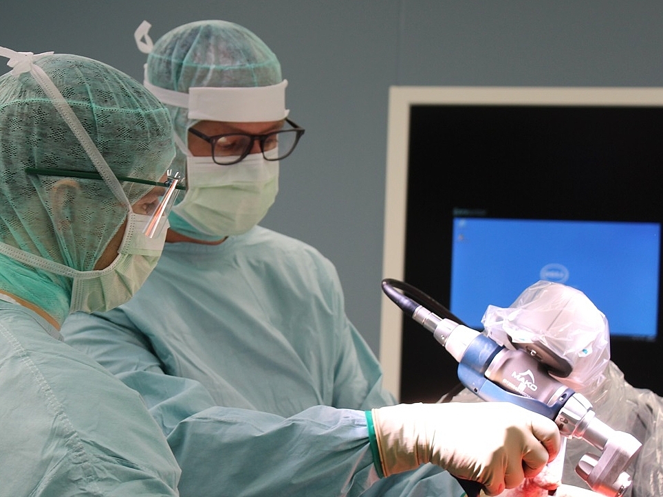 Roboterarm-assistierte Operation Ärzte bei einer roboterarm-assisitierten Operation