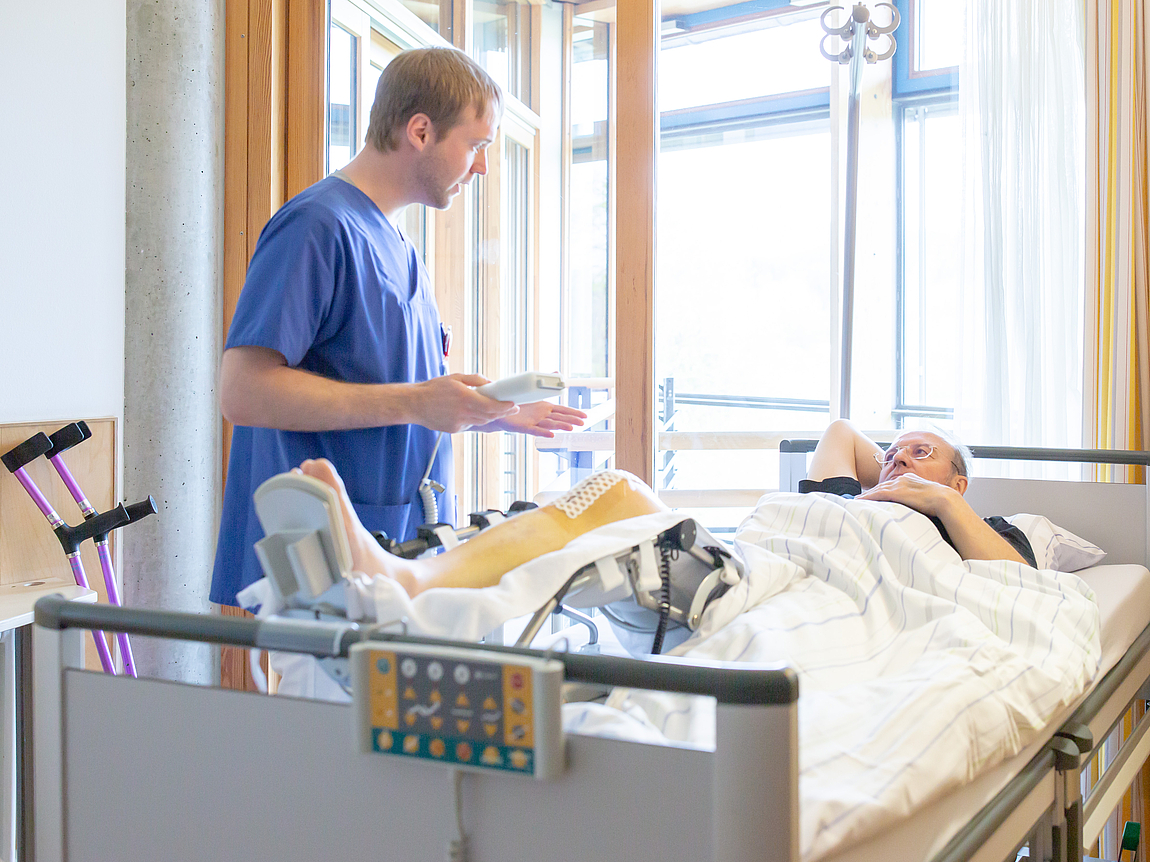 Medizinische Fachkraft am Krankenbett eines Patienten